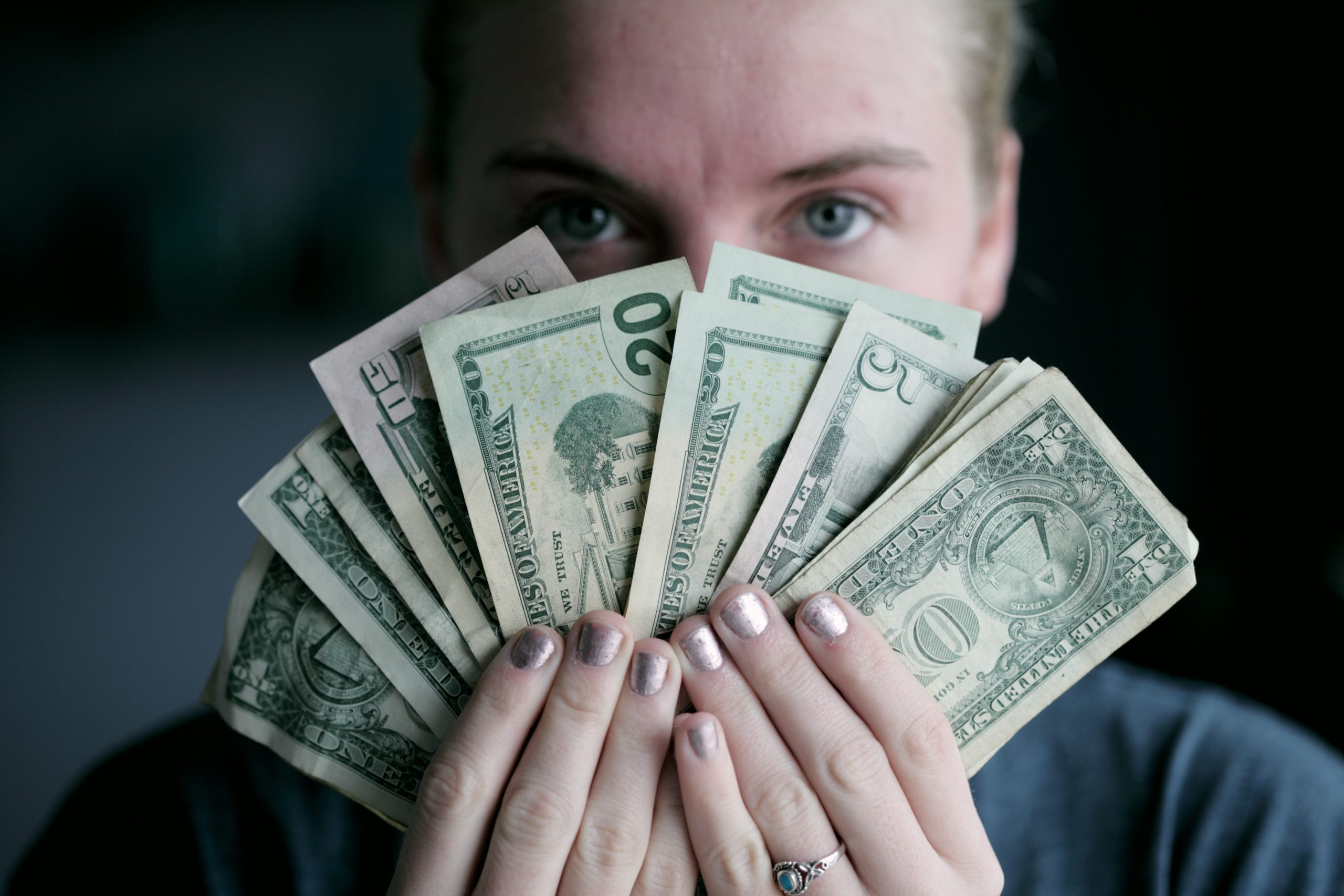 Person holding money - ROI from paying a fair living wage - Photo by Sharon McCutcheon on Unsplash